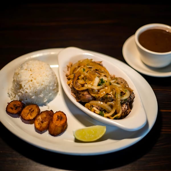 Cuban shredded beef with onions, white rice, fried plantains, and a lime wedge, with coffee.