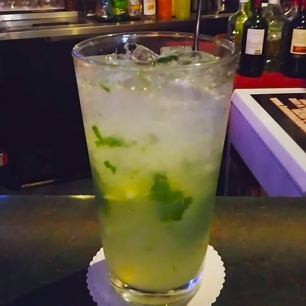 A refreshing mojito with ice and mint leaves on a bar counter at Havana Club Restaurant.